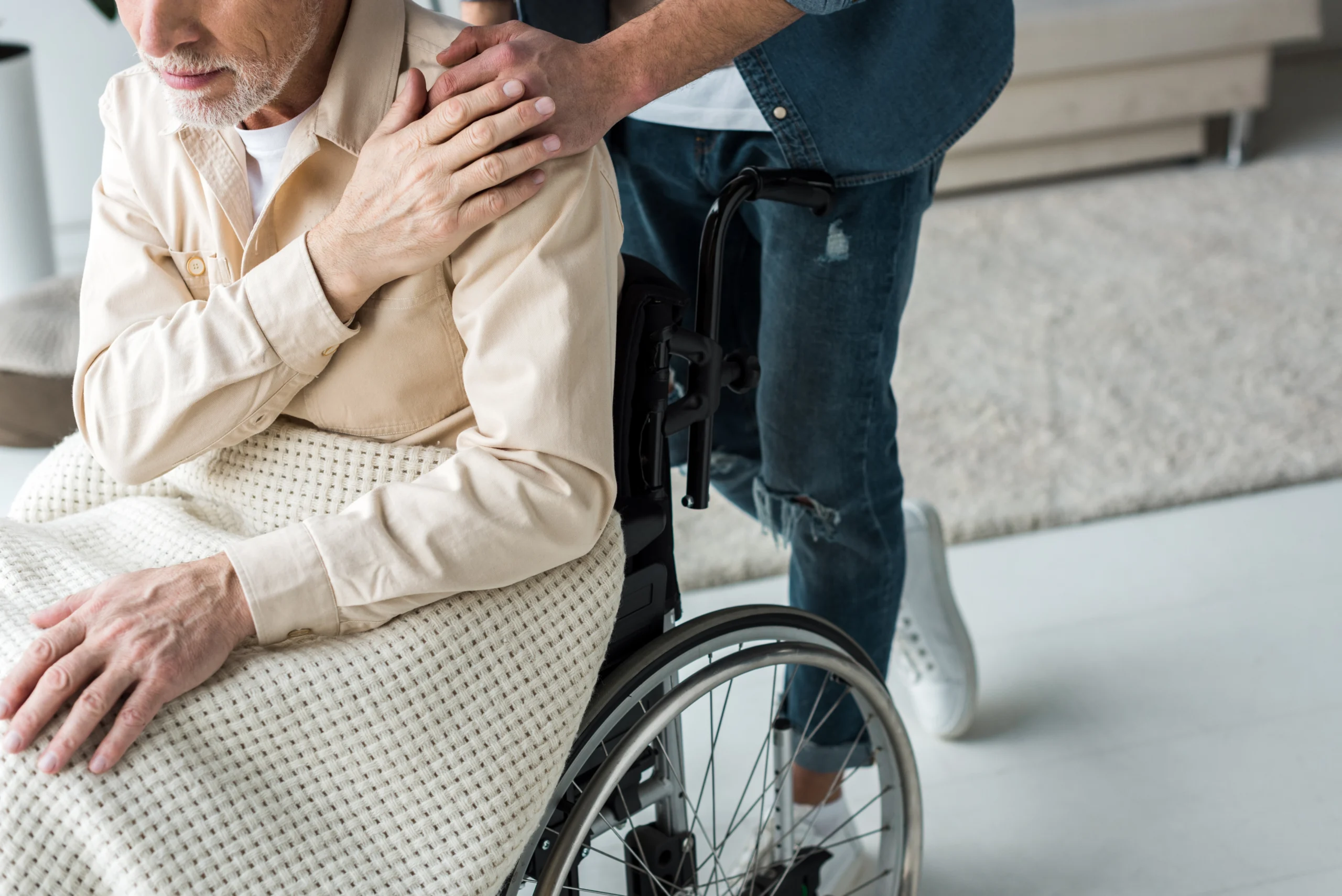aged-care-in-Minneapolis-MN-1 closeup of male caretaker placing hand on shoulder of elderly male