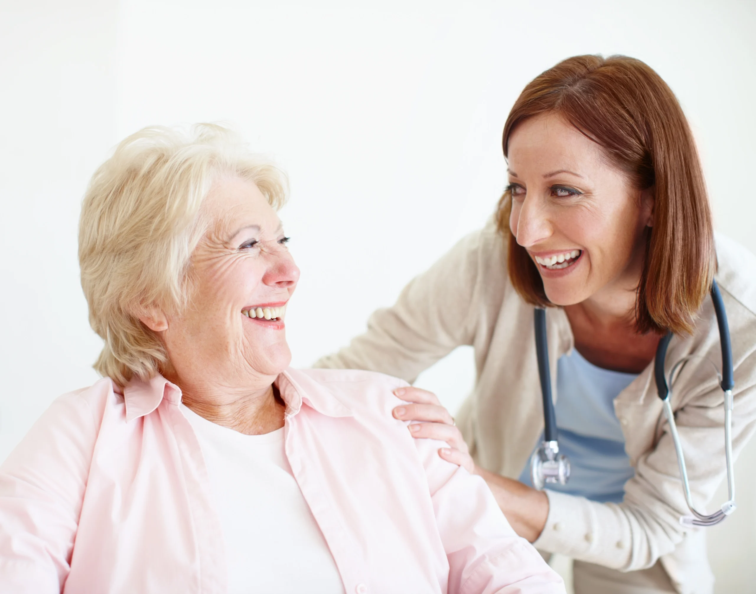 home-care-services-in-Rush-City-MN-2 senior woman laughing with healthcare nurse's hands on her shoulder