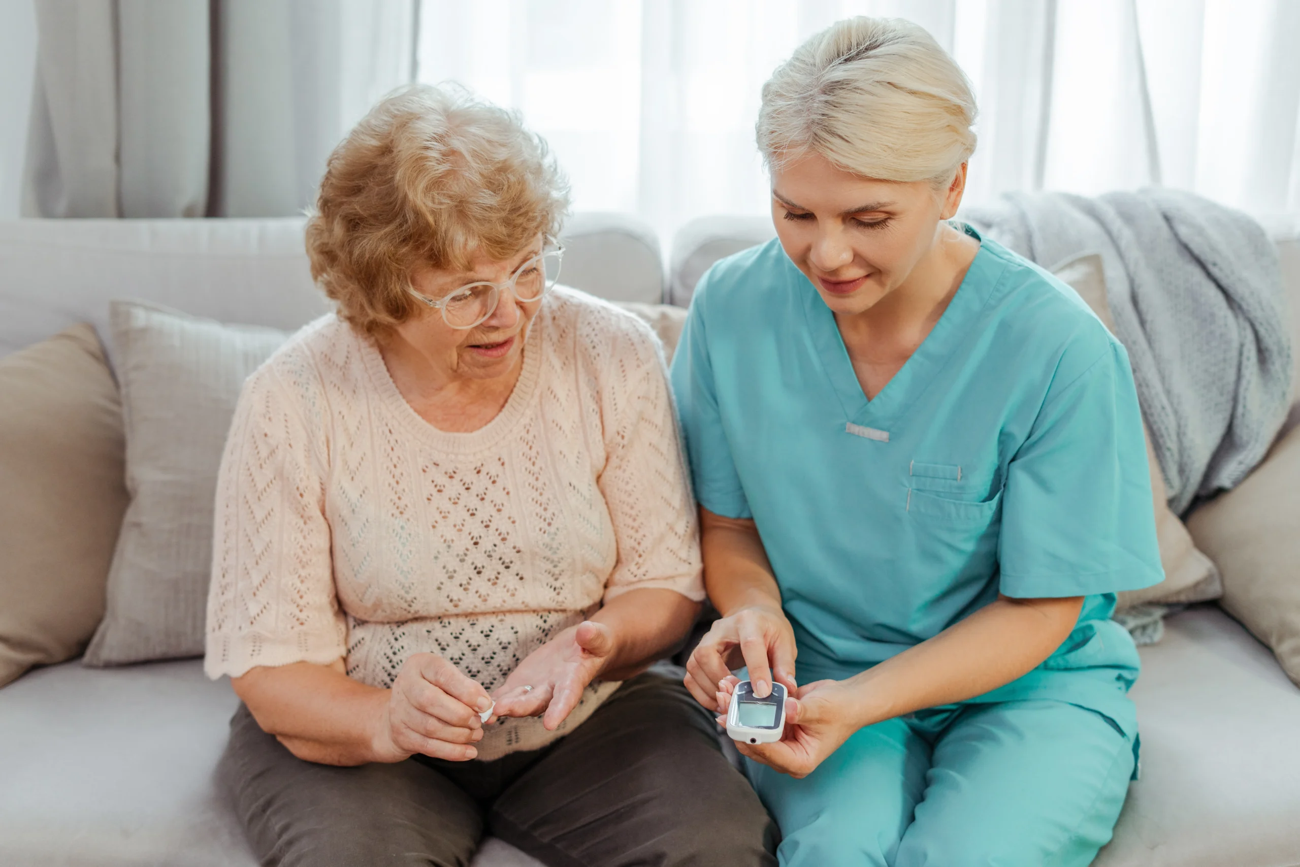 respite-home-care-in-Minneapolis-MN-2 nurse shows elderly woman how to check her blood sugar