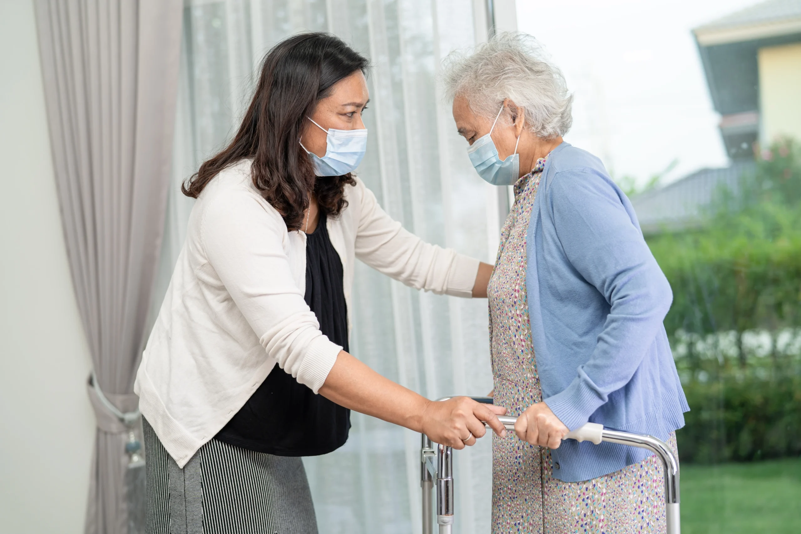 senior-home-care-in-Minneapolis-MN-2 asian caregiver helping elderly asian woman to use a walker