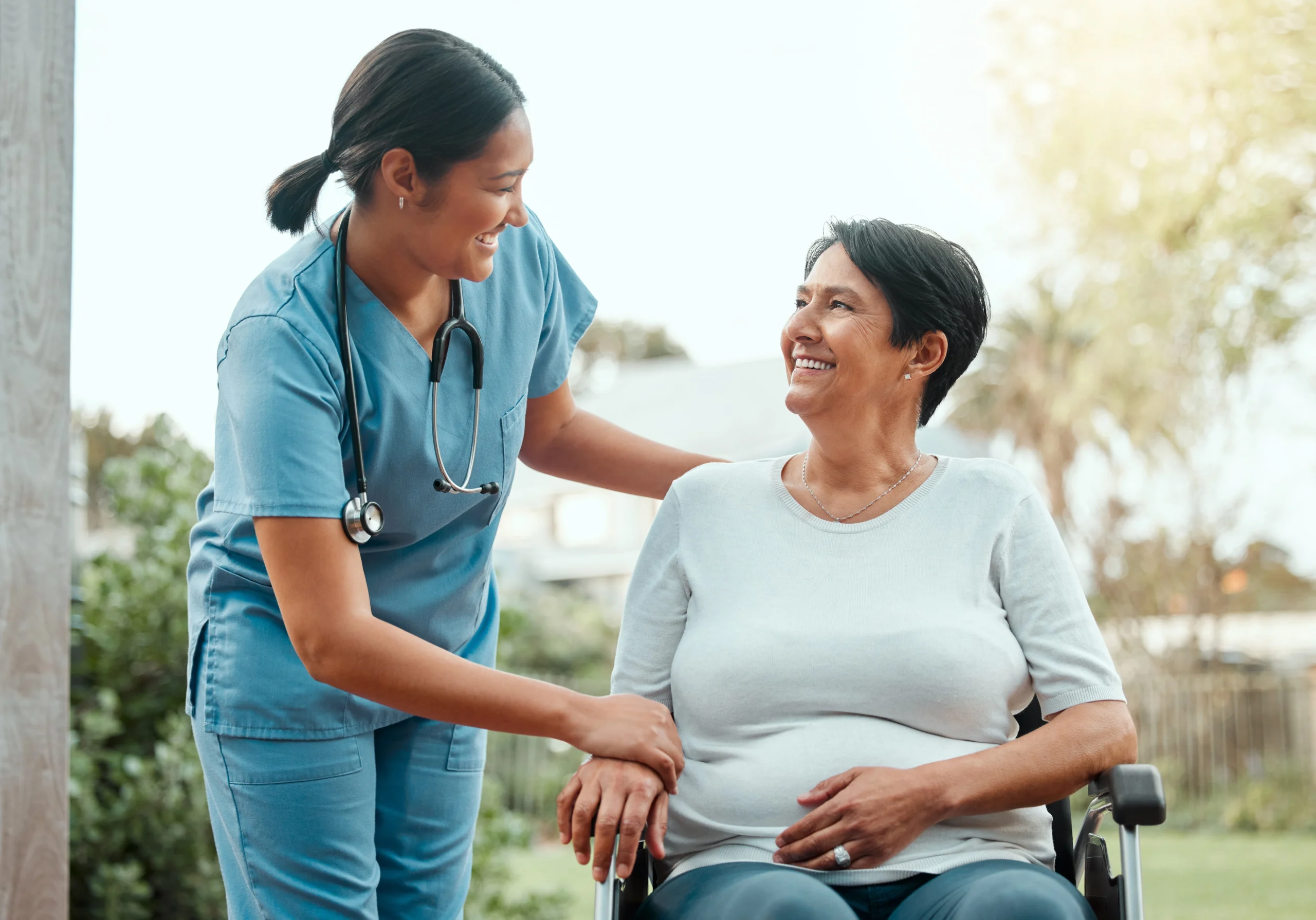 skilled-nursing-home-care-in-Minneapolis-MN-2 caring tanned nurse helps elder woman in wheelchair